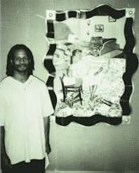 Brian Joiner standing beside his painting "Houseshoes."