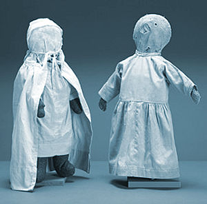 Two stuffed cloth dolls in dresses, handmade by the Amish.
